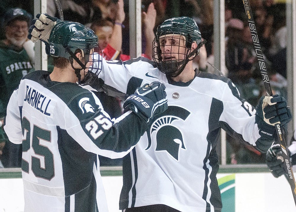	<p>From left, sophomore forward Brent Darnell and senior defenseman Matt Grassi celebrate after scoring a goal on Monday night, Oct. 8, 2012, at Munn Ice Arena. <span class="caps">MSU</span> defeated Windsor, 6-1in the first and only exhibition game. Adam Toolin/The State News</p>