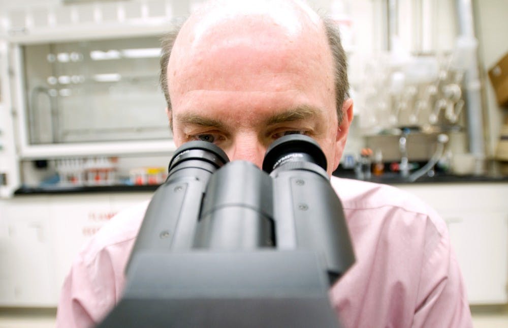 Assistant professor of pathobiology Dr. Jim Wagner examines a sample of air pathogens through a laboratory microscope Wednesday afternoon. Wagner is one of many researchers who works in the air laboratories for the newly formed Great Lakes Air Center for Integrated Research (GLACIER) at MSU. H?l?ne Dryden/The State News