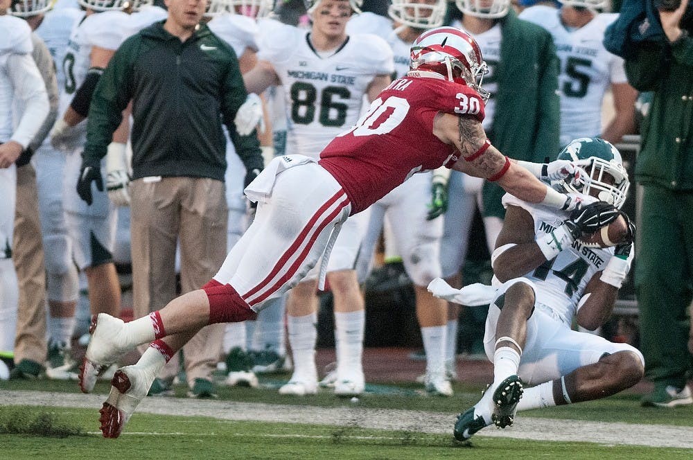 <p>Indiana safety Chase Dutra tackles senior wide reciever Tony Lippett during the game against Indiana on Oct. 18, 2014, at Memorial Stadium in Bloomington, Ind. The Spartans defeated the Hoosiers, 56-17. Jessalyn Tamez/The State News </p>