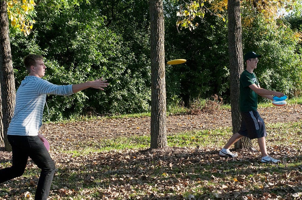 <p>International relations senior Eric Savoie and packaging junior Tyler Hanlon practice disc golf Oct. 1, 2014, at MSU Disc Course, 3600 Mount Hope Road, in East Lansing. Dylan Vowell/The State News</p>