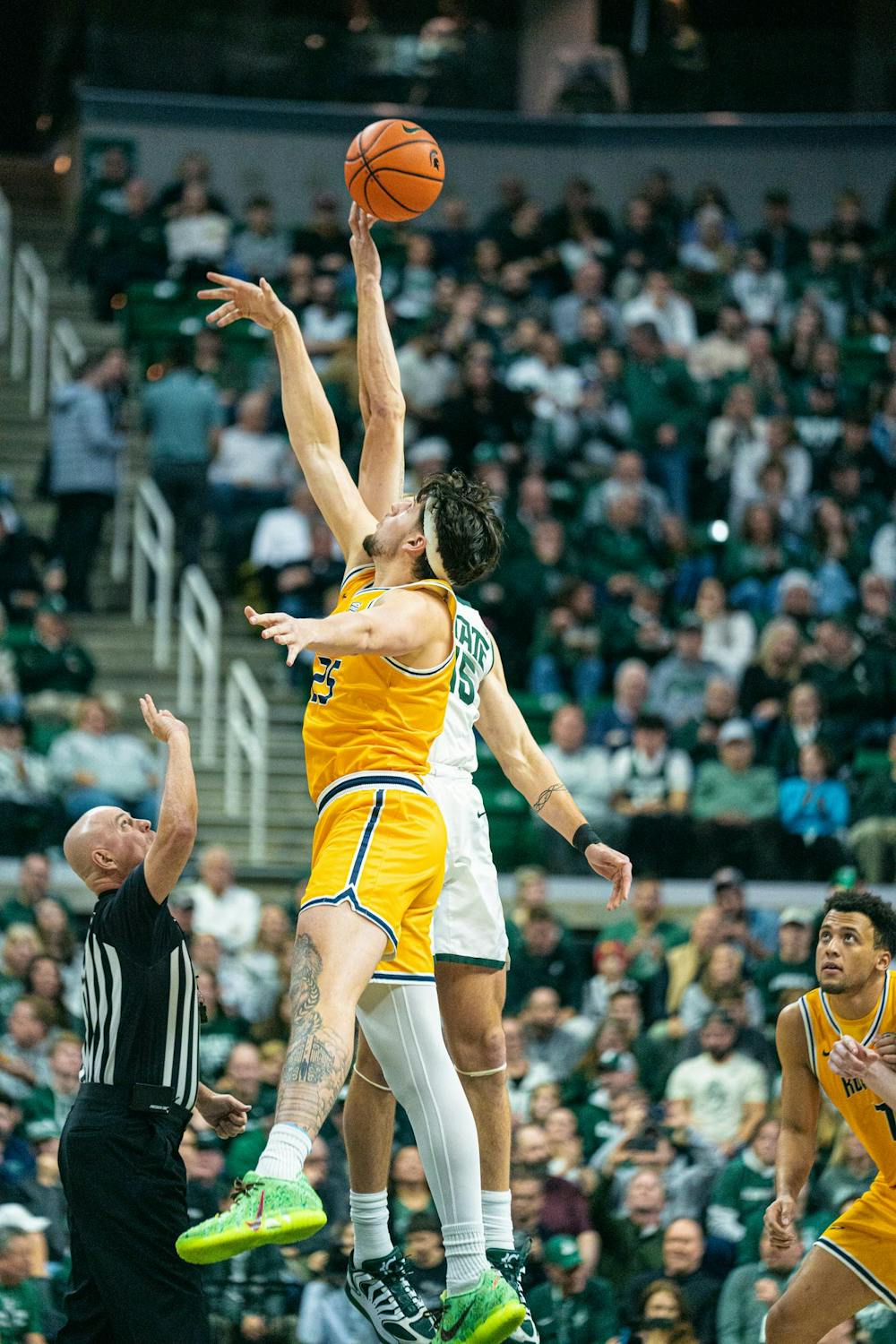 <p>Toledo junior center, Austin Parks (25) and MSU senior center, Carson Cooper (15) leap for the ball during the tip off at the Breslin Center in East Lansing, Michigan on Tuesday, Dec. 16, 2025.</p>