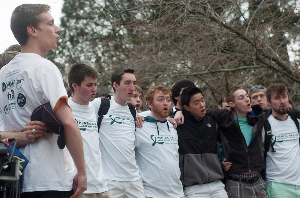 <p>The MSU Men's Glee Club performs the fight song April 10, 2014, at Beaumont Tower for Mental Health Awareness Week. Attendees heard from speakers about mental health stigmas. Meagan Beck/The State News</p>