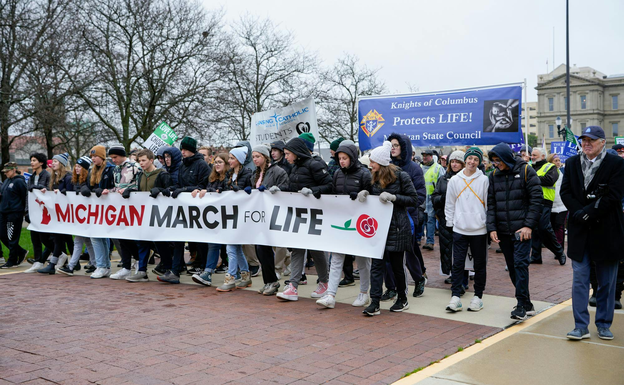 <p>Pro-life supporters hold a “Michigan March for Life” banner as they walk in protest from the Michigan State Capitol on Nov. 8, 2023.</p>