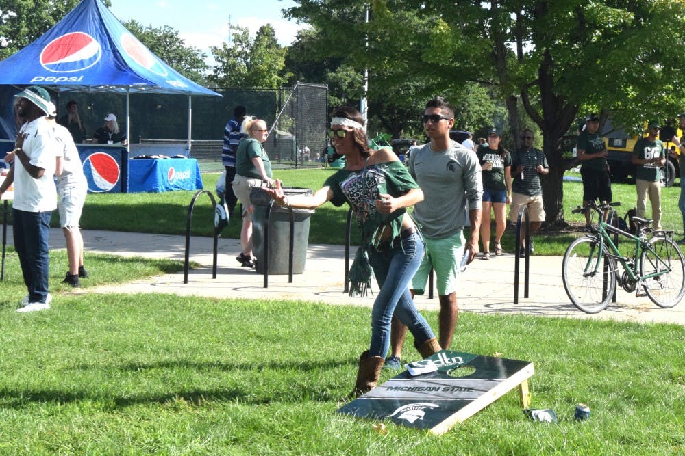 People play corn hole while tailgating before the MSU football game against Furman on Sept. 1, 2016 at the MSU tennis courts.