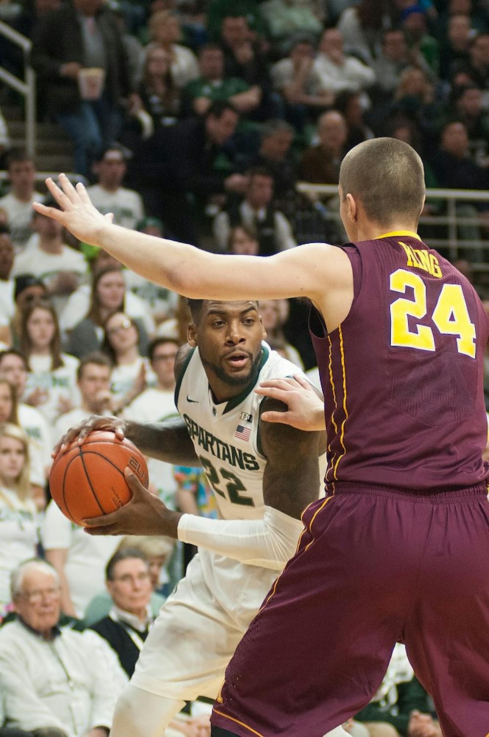 <p>Senior guard/forward Branden Dawson looks to pass around Minnesota forward Joey King Feb 26, 2015, during the game against Minnesota at Breslin Center. The Spartans fell to the Golden Gophers during overtime, 96-90. Kennedy Thatch/The State News</p>