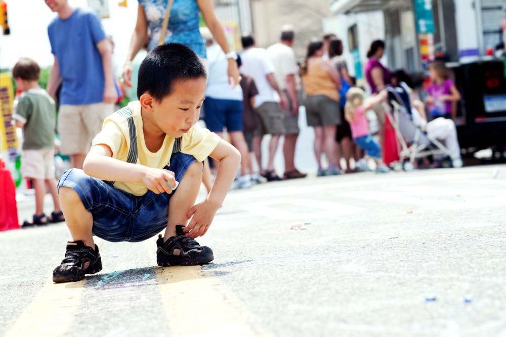 	<p>East Lansing resident Hanrui Ma colors with chalk on Abbott Rd. Saturday afternoon during the 48th Annual East Lansing Art Festival. The streets of downtown East Lansing were closed off for the weekend festival which gave local and national artists the opportunity to display and sell their work.</p>
