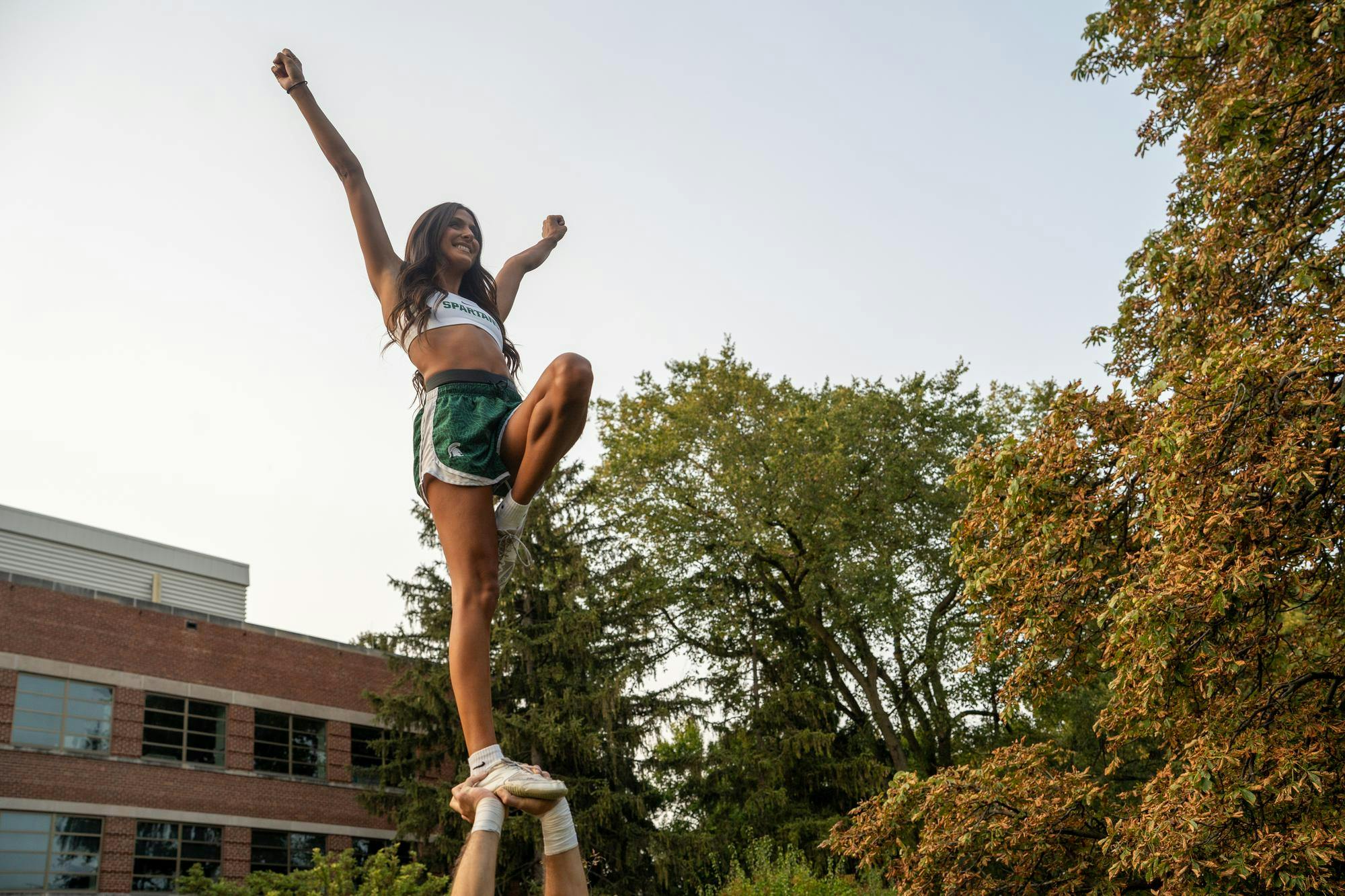 A Michigan State University cheerleader practices a stunt at Jenison Field House on September 11, 2024, in preparation for the MSU home football game.