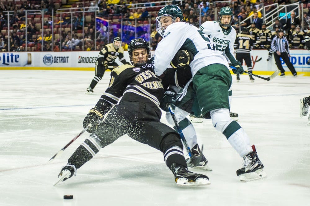 Redshirt freshman defenseman Jerad Rosburg (57) collides with Western Michigan wingman Frederik Tiffels (19) in the first period of the 52nd Annual Great Lakes Invitational semifinal game against Western Michigan during the Great Lakes Invitational on Dec. 29, 2016 at Joe Louis Arena in Detroit. 