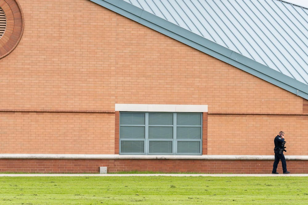 A police officer walks alongside Okemos High School following a "preventative lockdown" in Okemos, Michigan on May 29, 2025. 