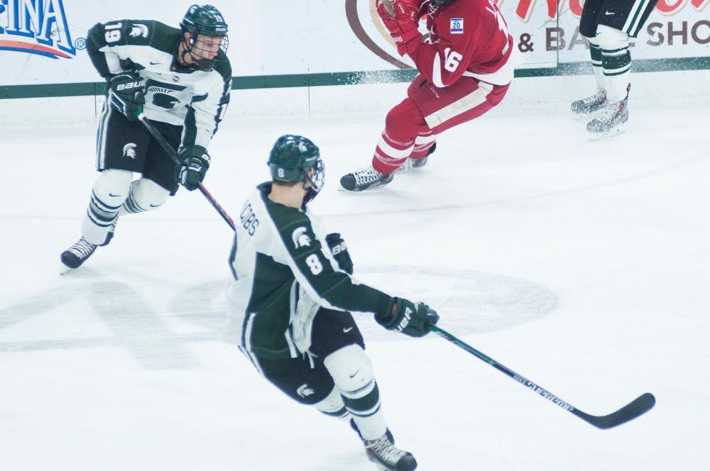 <p>Junior forward Matt DeBlouw takes the puck up the rink March 6, 2015, during the game against Wisconsin at Munn Ice Arena. The Spartans defeated the Badgers 3-0. Kennedy Thatch/The State News</p>