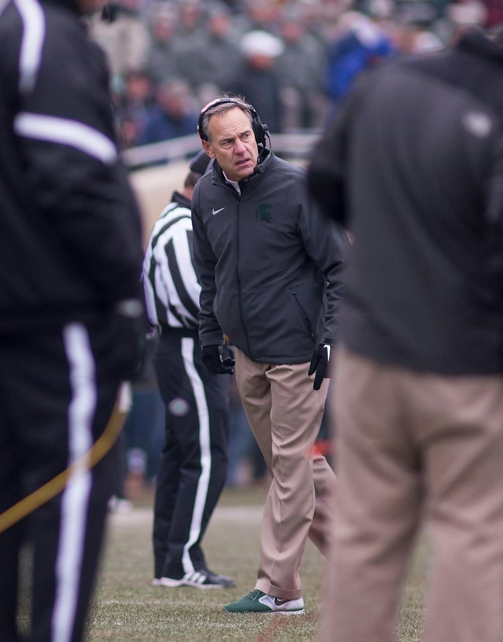 <p>Head Coach Mark Dantonio looks back at the field before the start of the next play Nov. 22, 2014, during the game against Rutgers at Spartans Stadium. The Spartans defeated the Scarlet Knights, 45-3. Erin Hampton/The State News</p>