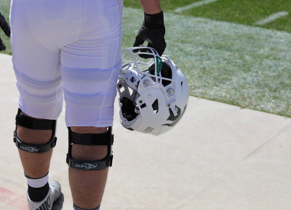 A player holds his helmet at the Green and White game at Spartan Stadium on April 13, 2019. The green team defeated the white team 42-26.