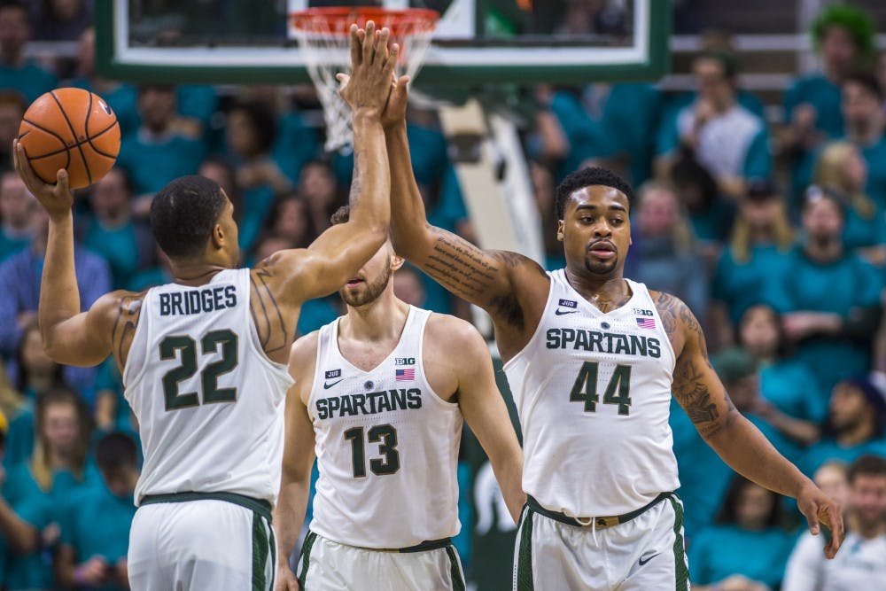 Sophomore guard Miles Bridges (22) high fives sophomore forward Nick Ward (44) during the first half of the men's basketball game against Wisconsin on Jan. 26, 2018 at Breslin Center. The Spartans defeated the Badgers, 76-61. (Nic Antaya | The State News)