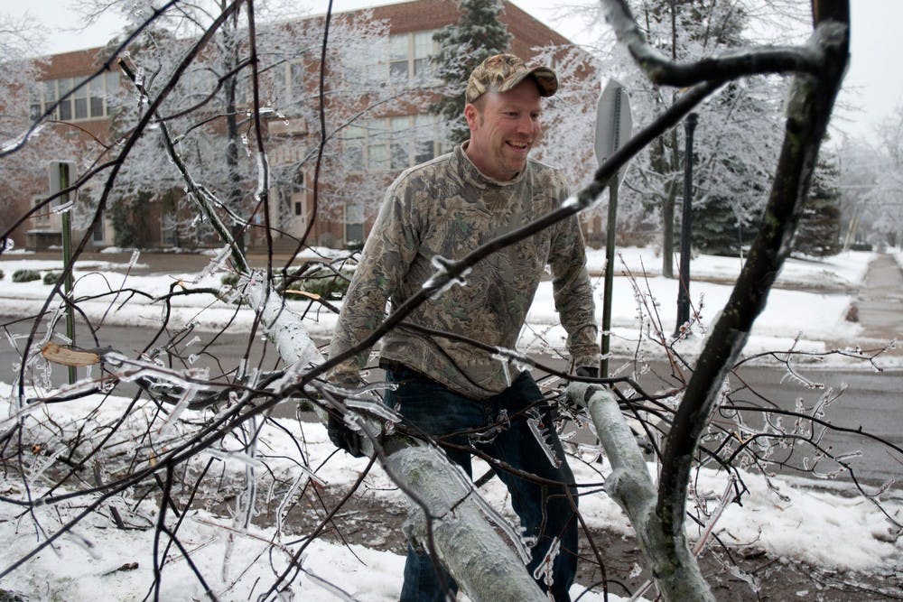 	<p>Landlord Dan Droste cleans fallen branches from the sidewalk Dec. 22, 2013, in front of a house on the corner of Bailey and Ann Street. The ice storm left many fallen branches and downed power lines. Julia Nagy/The State News </p>