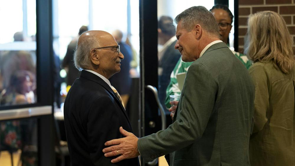 MSU President Kevin M. Guskiewicz greets Kunwar Rajendra, adjunct professor in the MSU Department of Electrical and Computer Engineering, at a reception following the 2026 State of the University Address at the Wharton Center for Performing Arts at MSU on Tuesday, Sep 29, 2026.