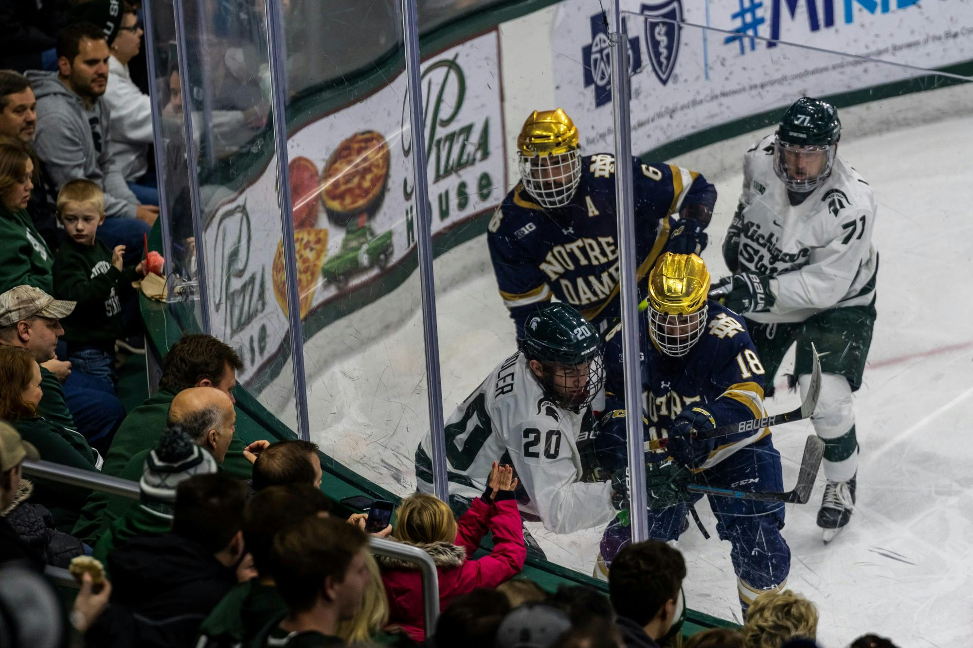 <p>Michigan State and Notre Dame players scrum in the corner trying to regain possession. The Spartans were defeated by the Fighting Irish, 2-1, on Nov. 22, 2019 at Munn Ice Arena.</p>