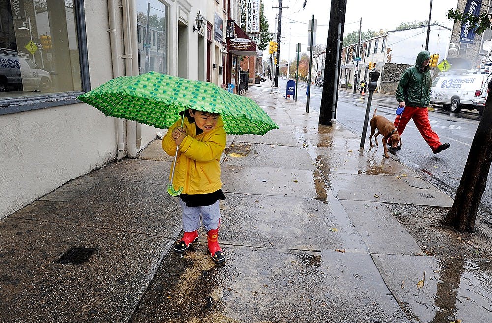 As the winds of hurricane Sandy blow across the region, Parker Kim, 3 years old, holds on as tight as he can to his umbrella on Main Street in Manayunk section of Philadelphia, Monday, October 29, 2012. He and his mother were walking looking for puddles for Parker to jump in. (Sharon Gekoski-Kimmel/Philadelphia Inquirer/MCT)