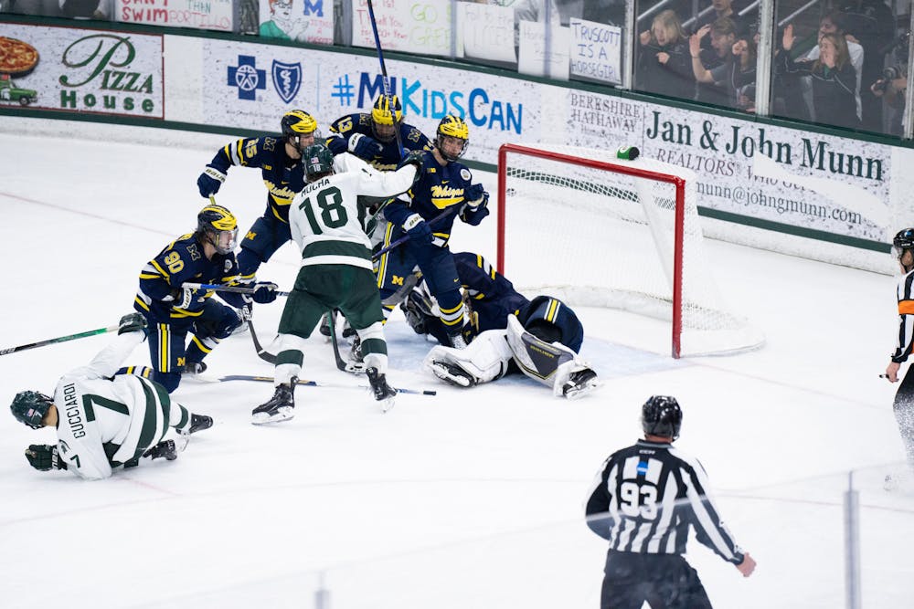 <p>A scrum ensues in front of the Michigan goal while U of M goalkeeper Erik Portillo attempts to freeze the puck at Munn Ice Arena in East Lansing on Friday, Feb. 10, 2023. Portillo recorded 30 saves against MSU.</p>