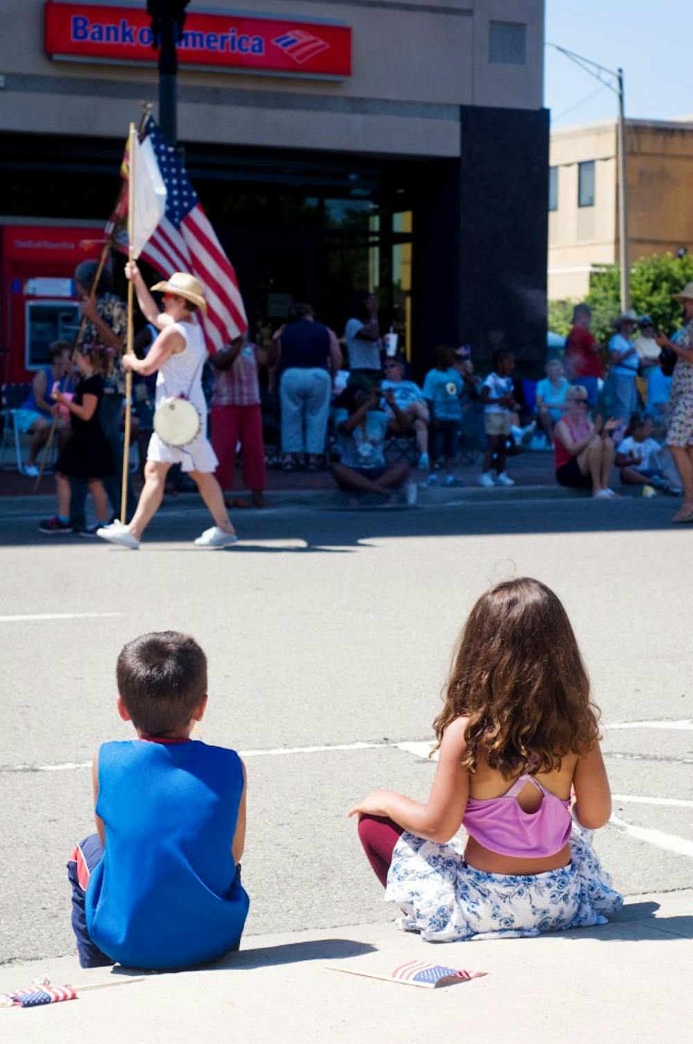 	<p>East Lansing residents Juston, 4, and Sommer, 5,  Aljaari watch as the City of Lansing July 4th parade marches past them Monday afternoon on W. Allegan St. Parade patrons plopped down on curbs and fold out chairs to watch a line of clowns, community groups, and specialty automobiles make their way around the Michigan State Capitol.</p>
