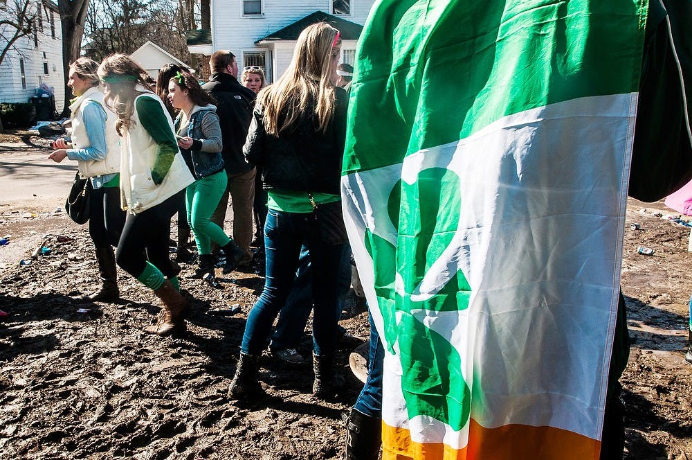 <p>Finance senior Sean Hancook wears a cape with a four-leaf clover for St. Paddy's day March, 17, 2014, outside a party on Collingwood Drive. Erin Hampton/The State News</p>