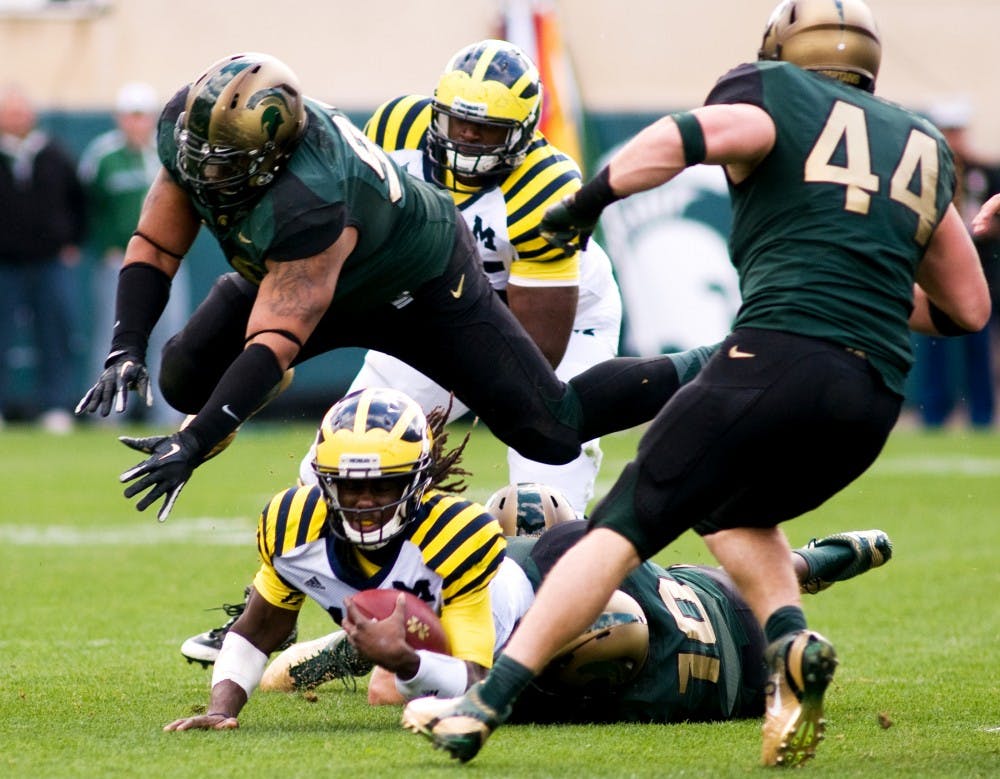 Junior defensive tackle Jerel Worthy soars over Michigan quarterback Denard Robinson after junior linebacker Chris Norman tackled Robinson during Saturday's game at Spartan Stadium. Lauren Wood/The State News