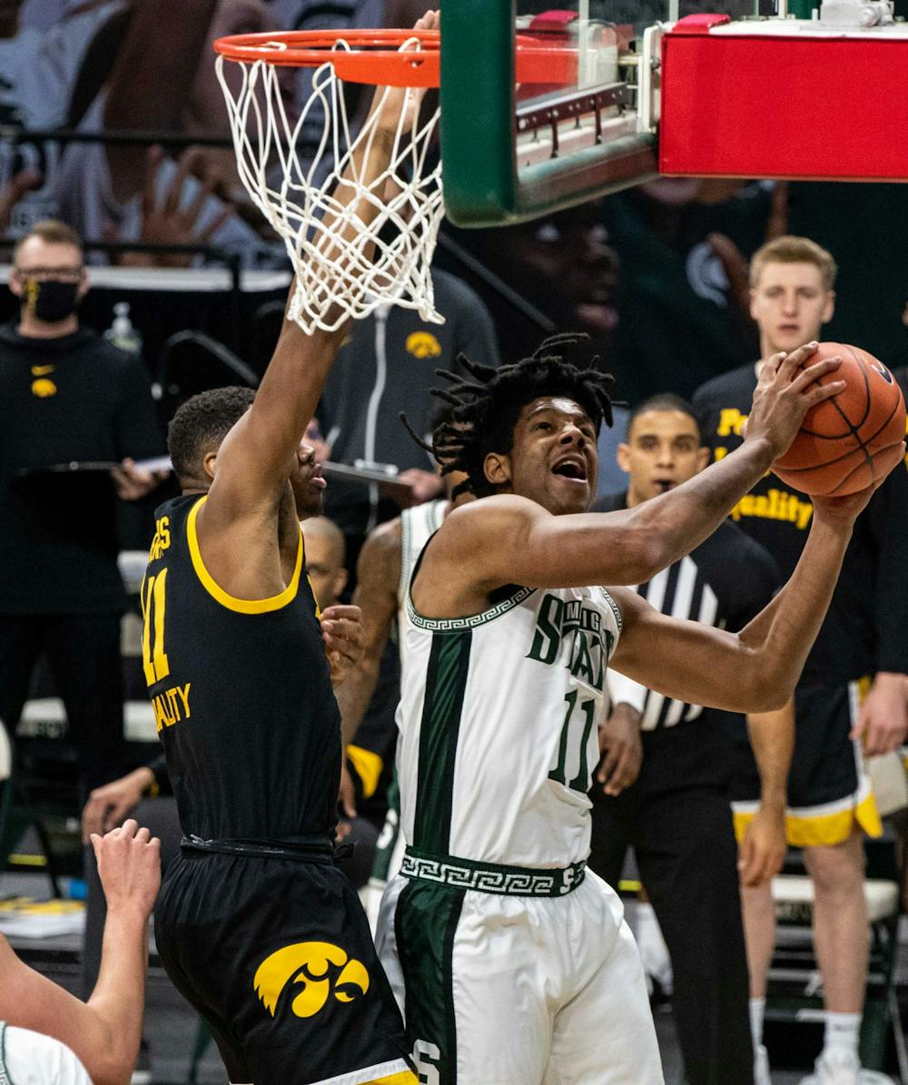 <p>Freshman guard A.J. Hoggard (11) tries to shoot around the Iowa defense in the first half but is unsuccessful. The Hawkeyes crushed the Spartans, 88-58, on Feb. 13, 2021.</p>