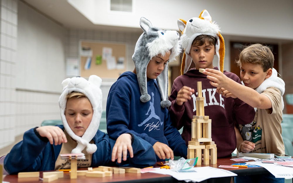 Odyssey of the Minds competitors from New York build block towers prior to competing in the Spontaneous part of the competition at Wells Hall in East Lansing, Michigan on May 22, 2025. 