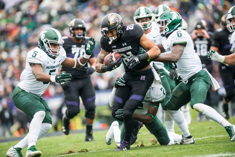 <p>Northwestern wide receiver Ramaud Chiaokhiao-Bowman is brought down by a group of Spartan defenders led by sophomore cornerback Justin Layne (2) during the game against Northwestern on Oct. 28, 2017, at Ryan Field. The Spartans fell to the Wildcats, 39-31, in 3OT.</p>
