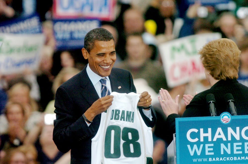 Sen. Barack Obama D.-Ill. holds an "Obama 08" Michigan State jersey given to him at the Barack Obama rally in Adams field on Thursday. Gabrielle Moore/The State News