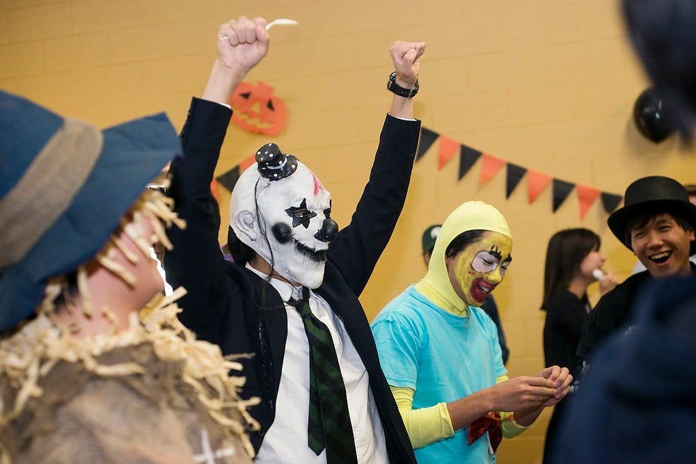 <p>Intercultural communication and language program sophomore Shu Toyoda cheers after finishing a relay game Oct. 26, 2014, during the Japan Club's annual Curry Party at the Spartan Village Community Center, 1460 Middlevale Road in East Lansing. Japanese curry and bubble tea from Bubble Island was served at the Halloween themed party. Erin Hampton/The State News</p>