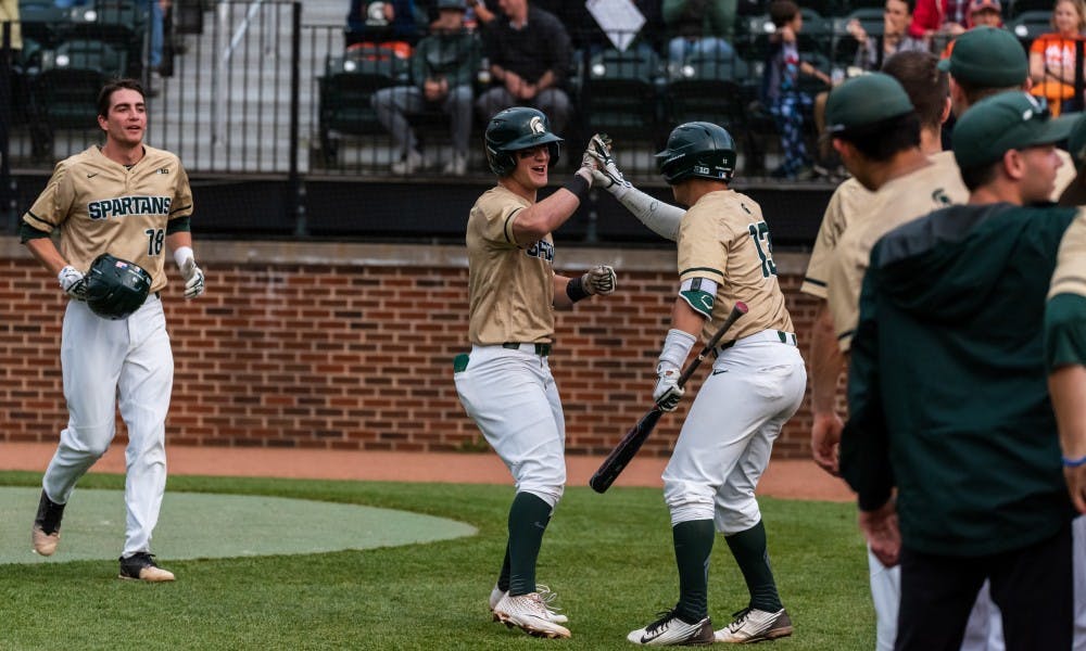 <p>Senior shortstop Marty Bechina (2) celebrates with senior second baseman Royce Ando (13) after hitting a home run against Illinois. The Spartans beat the Fighting Illini, 5-2, at McLane Baseball Stadium on May 17, 2019. </p>