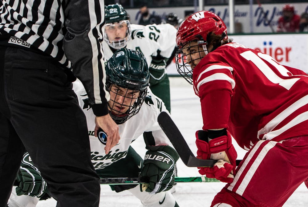 Freshman defender Aiden Gallacher (2) faces off against a Wisconsin player in the second period. The Badgers shut out the Spartans 4-0 at Munn Ice Arena on Mar. 5, 2021. 