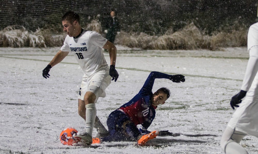 Senior defender Connor Corrigan (16) beats out a UIC player for the ball during the game against University of Illinois at Chicago at DeMartin Stadium on Nov. 15, 2018. The Spartans defeated the Flames, 2-0.