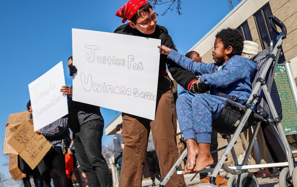 <p>Attendee Malijah Edsall-Parr, 9, right, reaches out to Ruby Solis Cotchran, left, and their sign at the Lansing Police brutality protest in front of the East Lansing Police Station and 54B District Court on Feb. 23, 2020.</p>