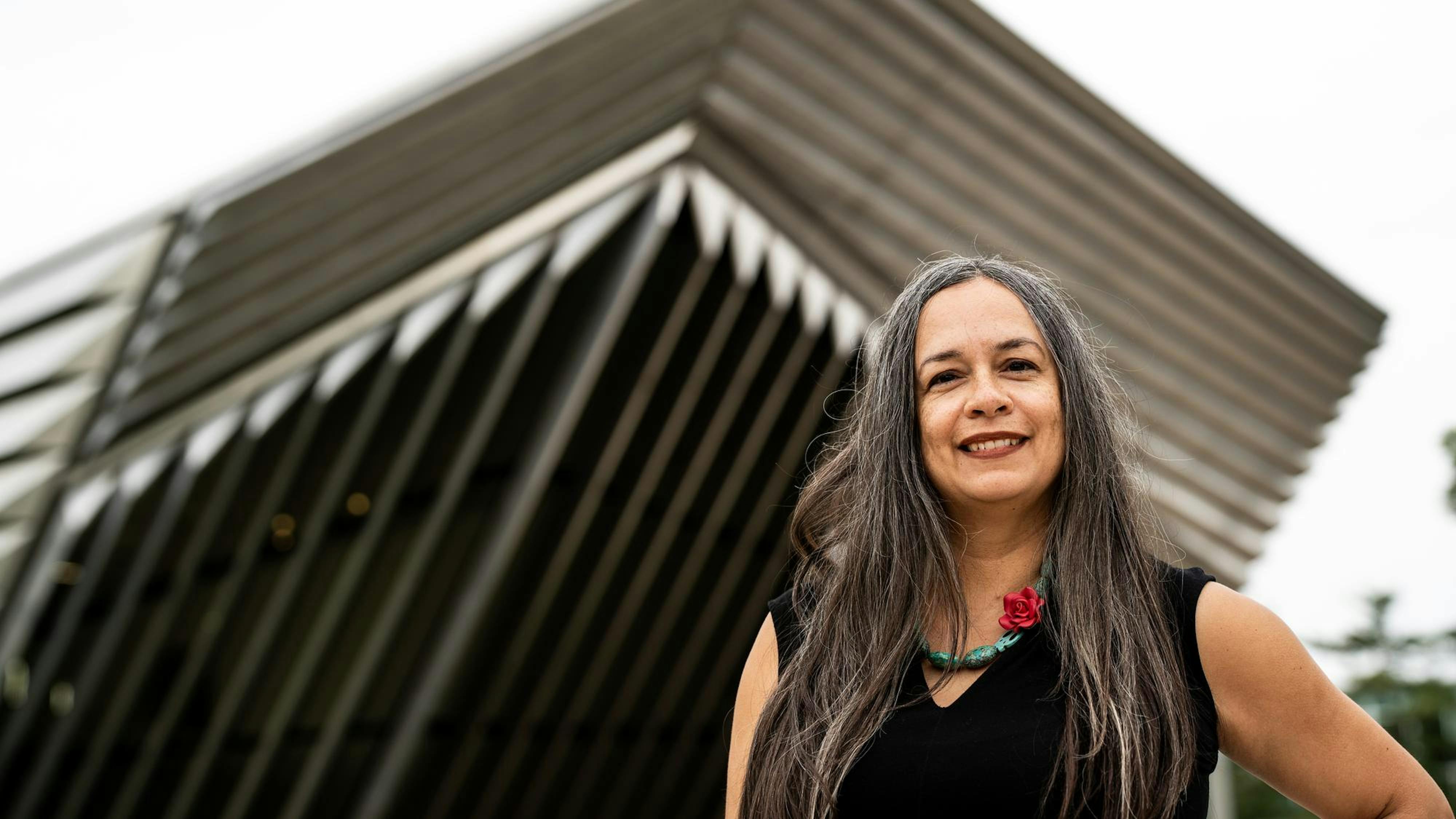 Teresa Dunn, artist of the painting, "A Long Line of Women," poses in front of the Eli & Edythe Broad Art Museum in East Lansing, Michigan, on May 9, 2024. 