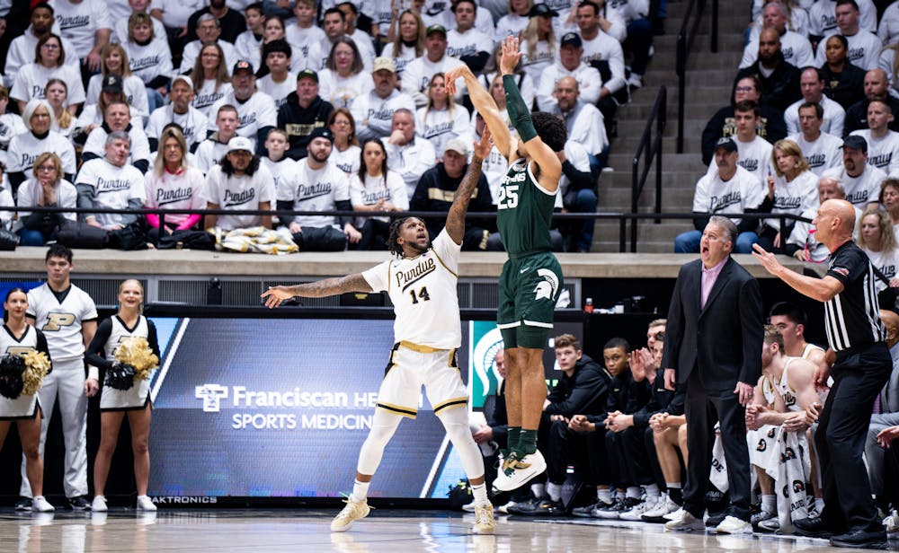 <p>Senior forward Malik Hall (25) attempts to shoot a three-pointer as Purdue's senior guard David Jenkins (14) guards him during a game against Purdue at Mackey Arena on Jan. 29, 2023. The Spartans lost to the Boilermakers 77-61.</p>