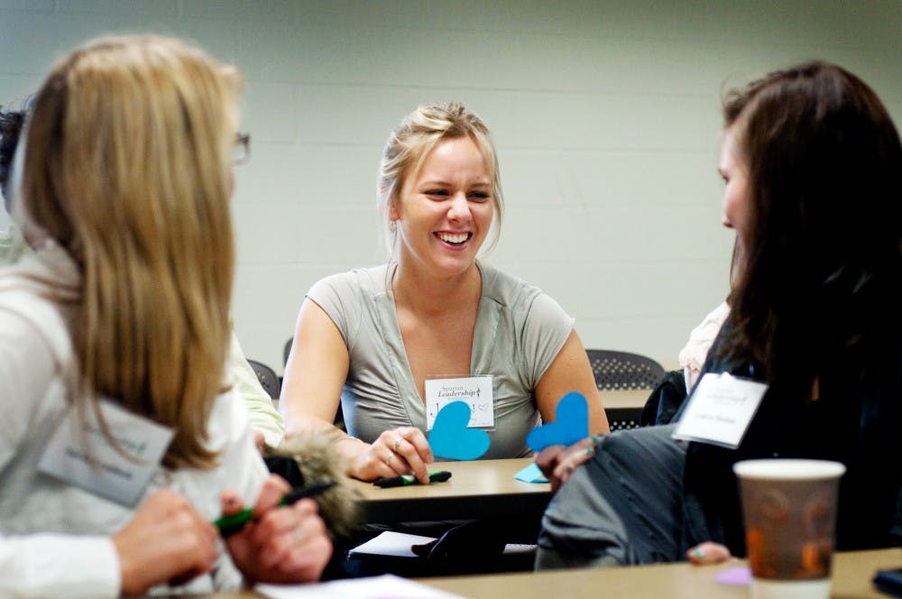 Special education junior Jaclyn Hoover, center, laughs as she compares words she wrote that describe love to computer science engineering sophomore Sarah Craddock, left, and communication sophomore Lauren Shelton, right, for an icebreaker activity during The Five Love Languages session at the Spartan Leadership Conference on Saturday afternoon in Snyder Hall. Josh Radtke/The State News