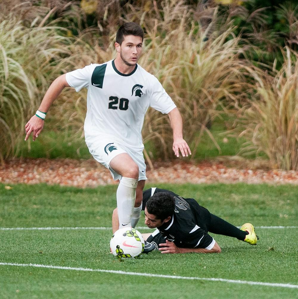 <p>Junior midfielder Jason Stacy steals the ball from Broncos defender Sean Hazen on Oct. 15, 2014, at DeMartin Soccer Stadium at Old College Field. The Spartans defeated the Broncos, 4-0. Aerika Williams/The State News</p>