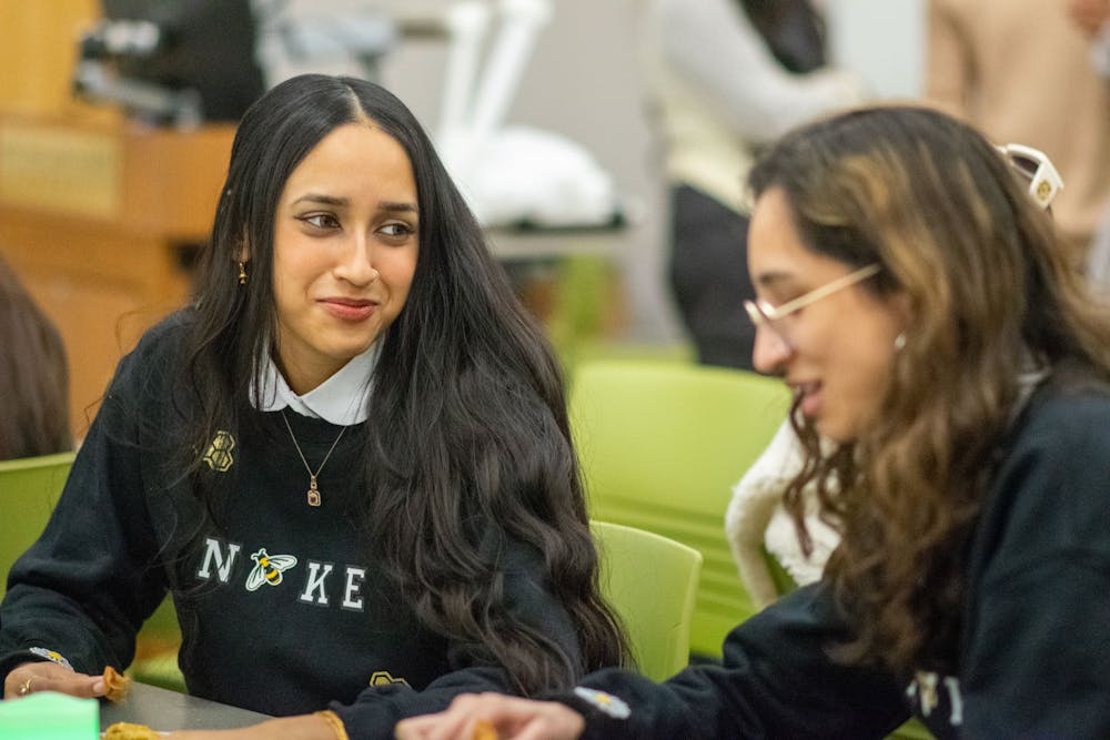 <p>Tasfia Ahmed, junior comparative cultures and politics, enjoys samosas with her friend Izza Ali, junior neuroscience, before the getting ready for Ramadan meeting on March 31, 2022. </p>