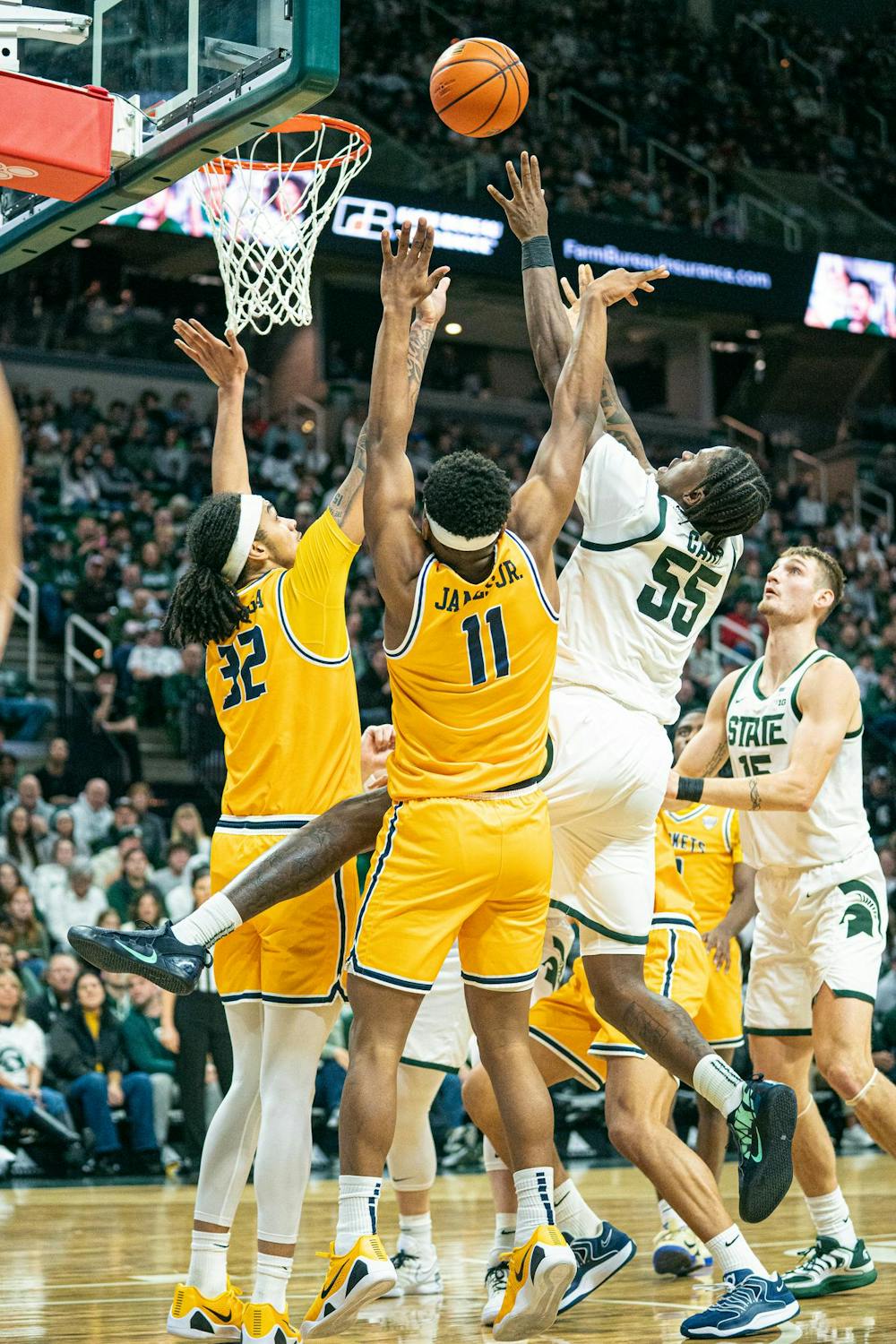 <p>MSU junior forward, Coen Carr (55) leaps for a shot as Toledo sophomore forward, Jaylan Ouwinga (32) and freshman guard, Will James Jr. (11) jump to try and defend during the MSU versus Toledo matchup at the Breslin Center in East Lansing, Michigan on Tuesday, Dec. 16, 2025.</p>