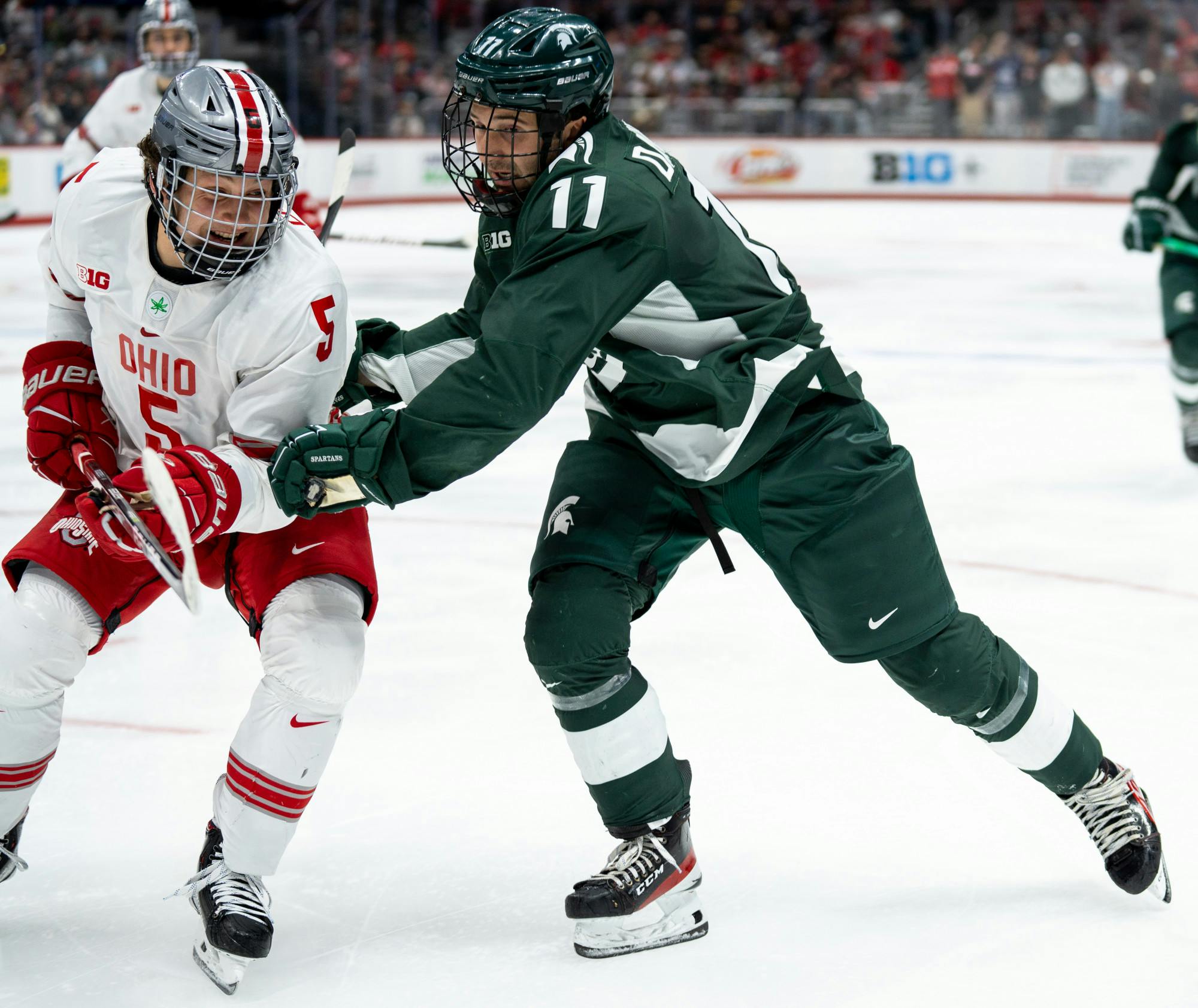 <p>Junior forward Jeremy Davidson (11) fights off Ohio State player during a game at Schottenstein Center on Jan 7, 2023. The Spartans fell to the Buckeyes with a score of 6-0. </p>