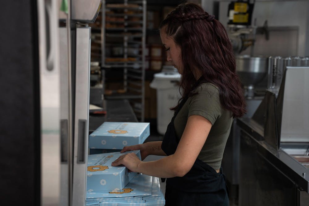 <p>A worker folds boxes for mochi donuts at Mochinut in East Lansing, Mich., on Sept. 8, 2026.</p>