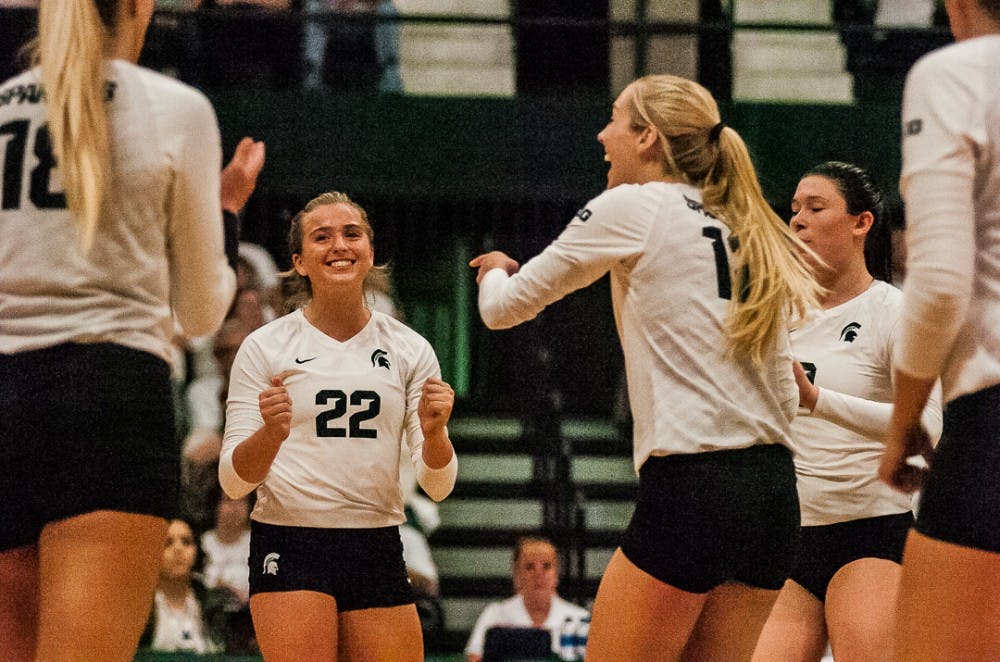 Sophomore defensive specialist Samantha McLean (22) reacts to a successful play with her teammates during the game against Michigan on Oct. 18, 2017 at Jenison Fieldhouse. The Spartans secured a 3-1 win against the Wolverines. 