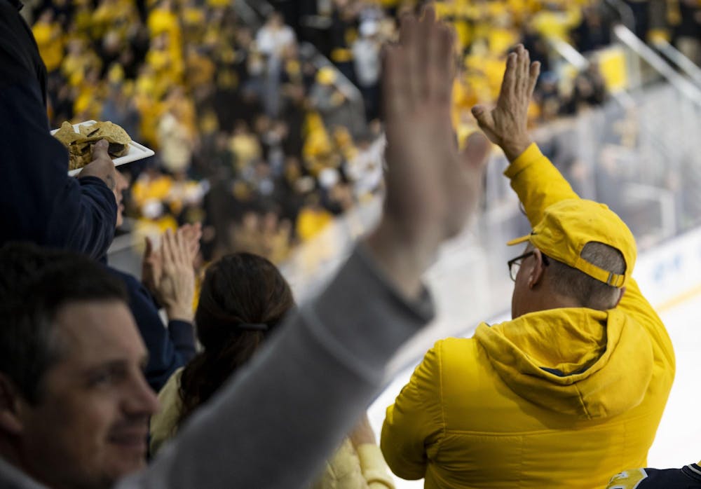 <p>University of Michigan fans high five after UM scored against MSU at the Yost Ice Arena in Ann Arbor, Mich. on Dec. 6, 2025.</p>