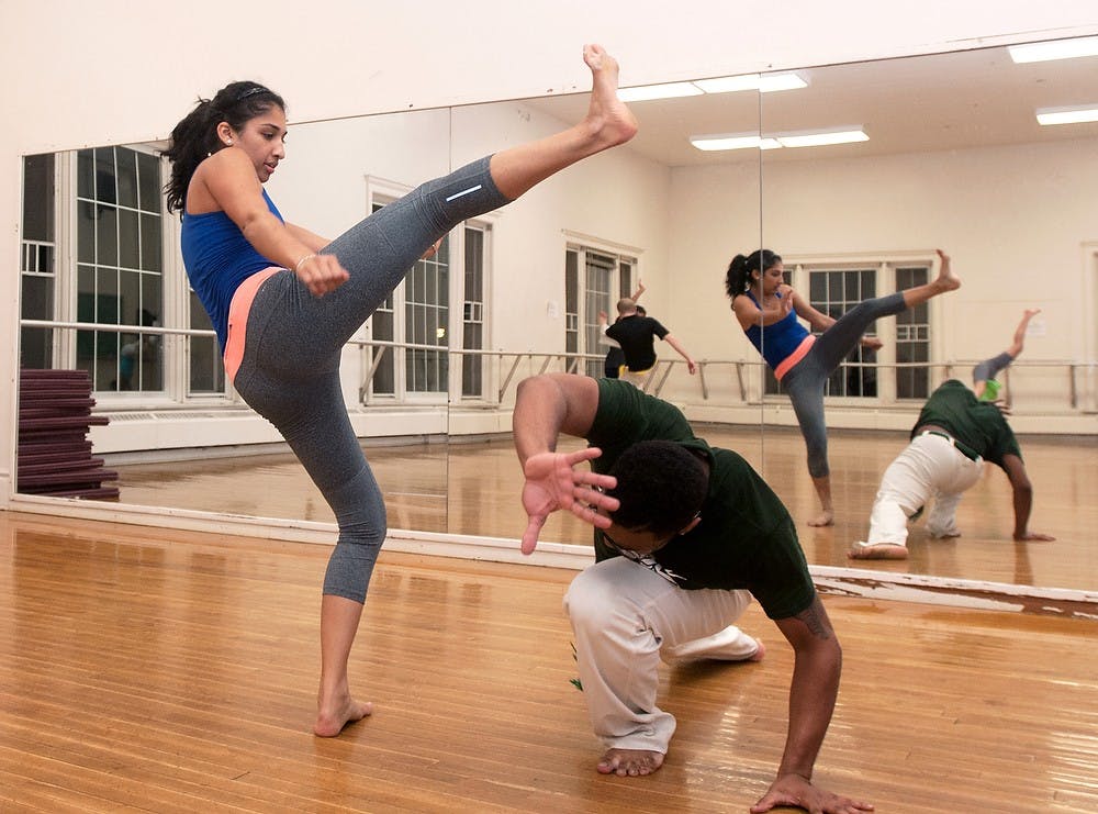 	<p>Marketing sophomore Erica Gohil and neuroscience sophomore Joey Hemingway practice Capoeira on Oct 30, 2013, at IM Sports-Circle. Capoeira is a martial art that combines fight and dance movements. Georgina De Moya/The State News</p>