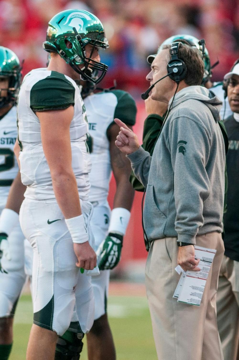 	<p>Head coach Mark Dantonio talks things over with sophomore quarterback Connor Cook during the game against Nebraska on Nov. 16, 2013, at Memorial Stadium in Lincoln, Neb. The Spartans defeated the Cornhuskers, 41-28. Khoa Nguyen/The State News</p>