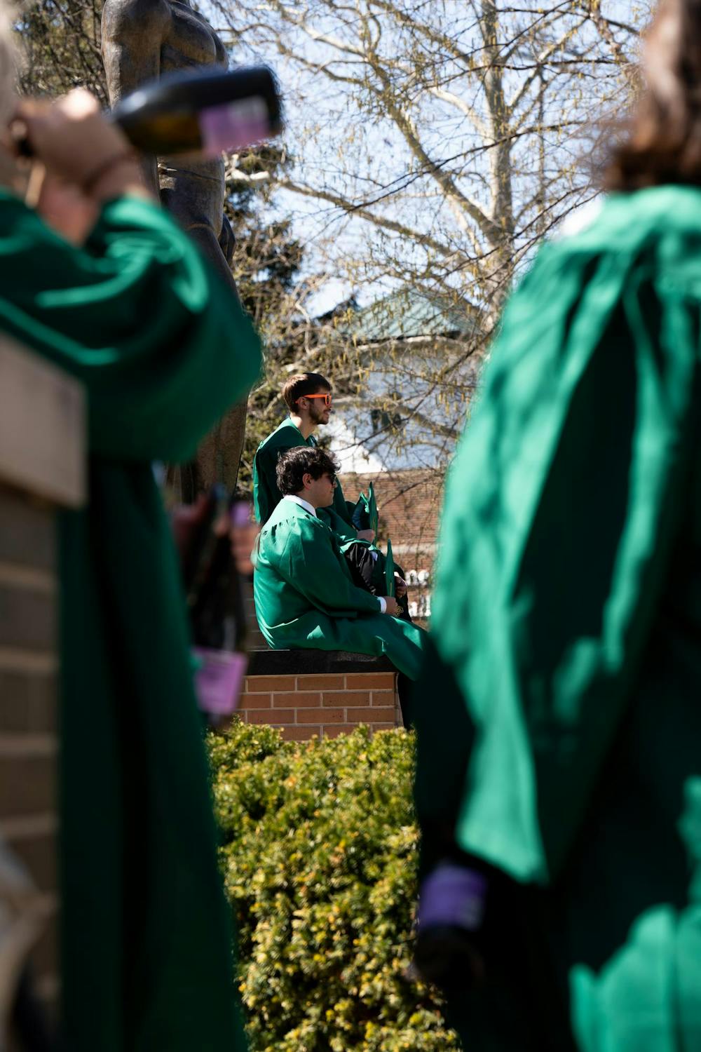 Michigan State Seniors pose for their portraits at the Sparty Statue on campus on April 19, 2024. Seniors often have to wait in line for the best spots on campus to get their portraits taken. 