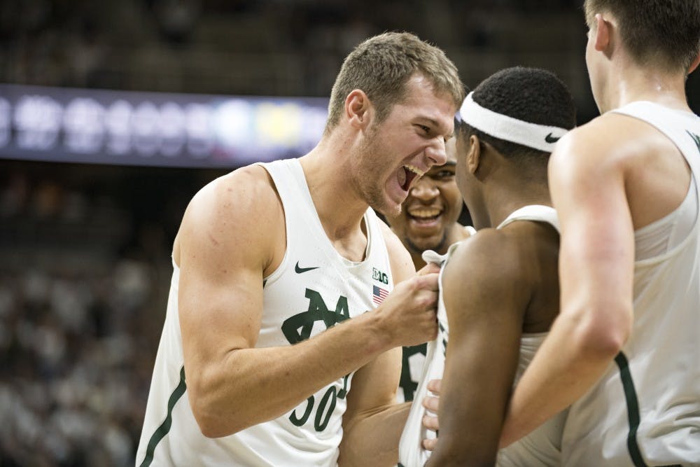 Senior forward Matt Van Dyk (30) grabs freshman guard Cassius Winston (5) as they celebrate during second half of the men's basketball game against the University of Michigan on Jan. 29, 2017 at Breslin Center. The Spartans defeated the Wolverines, 70-62.