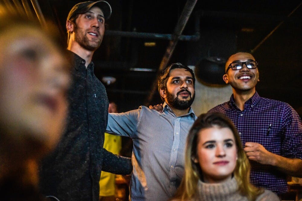 <p>Political science senior Aaron Stephens, center, reacts after realizing he has won a seat on East Lansing City Council on Nov. 7, 2017 at Hopcat.&nbsp;</p>