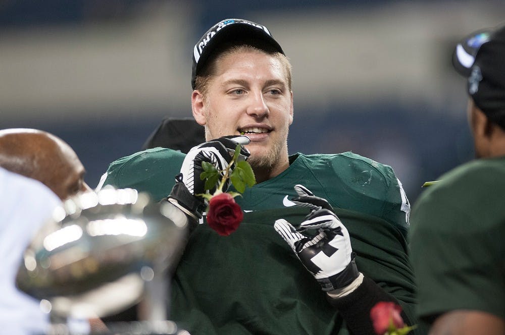 	<p>Senior linebacker Max Bullough sticks a rose in his mouth following the Big Ten Championship game against Ohio State on Dec. 7, 2013, at Lucas Oil Stadium in Indianapolis, Ind. The Spartans defeated the Buckeyes, 34-24. Danyelle Morrow/The State News</p>